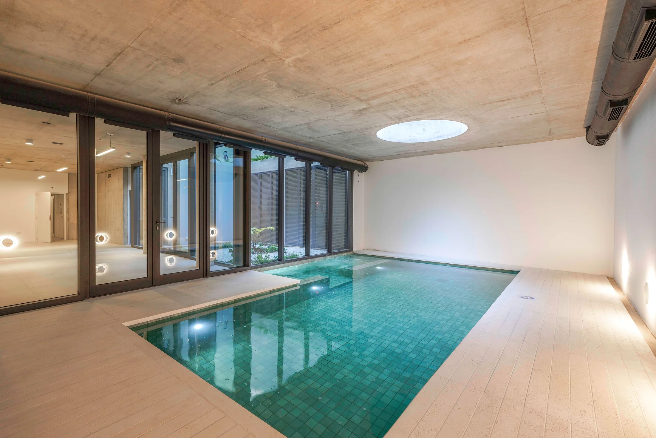 Piscina interior de Domos Plaza con ventanales y luz cenital